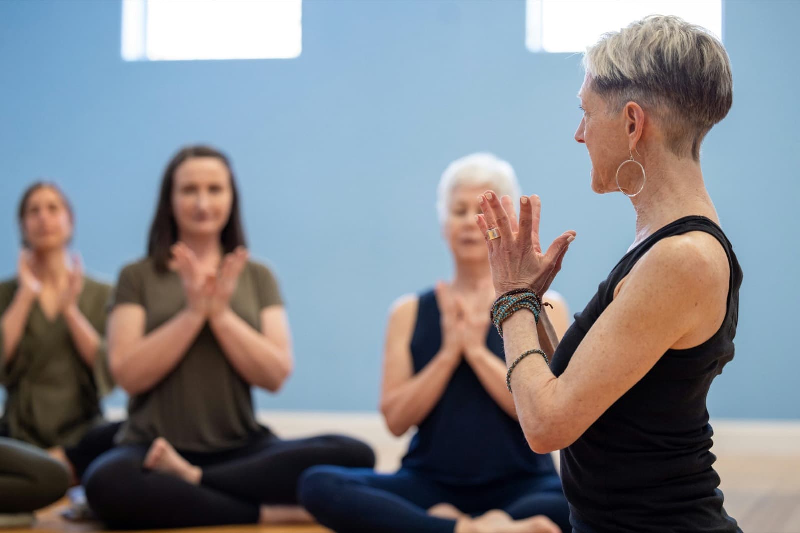 A teacher guiding a yoga class at Asheville Yoga Center